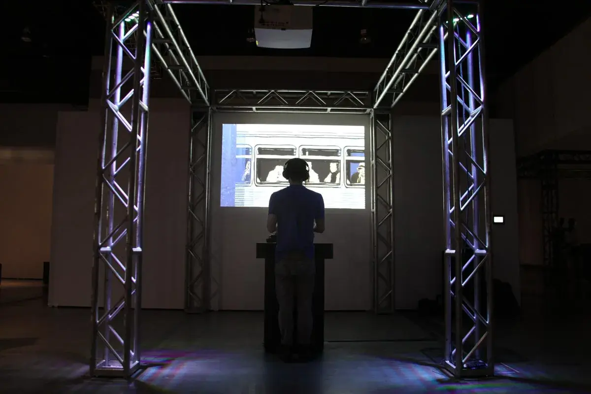 Visitor interacting with the installation at SIGGRAPH, silhouetted against the projected subway window