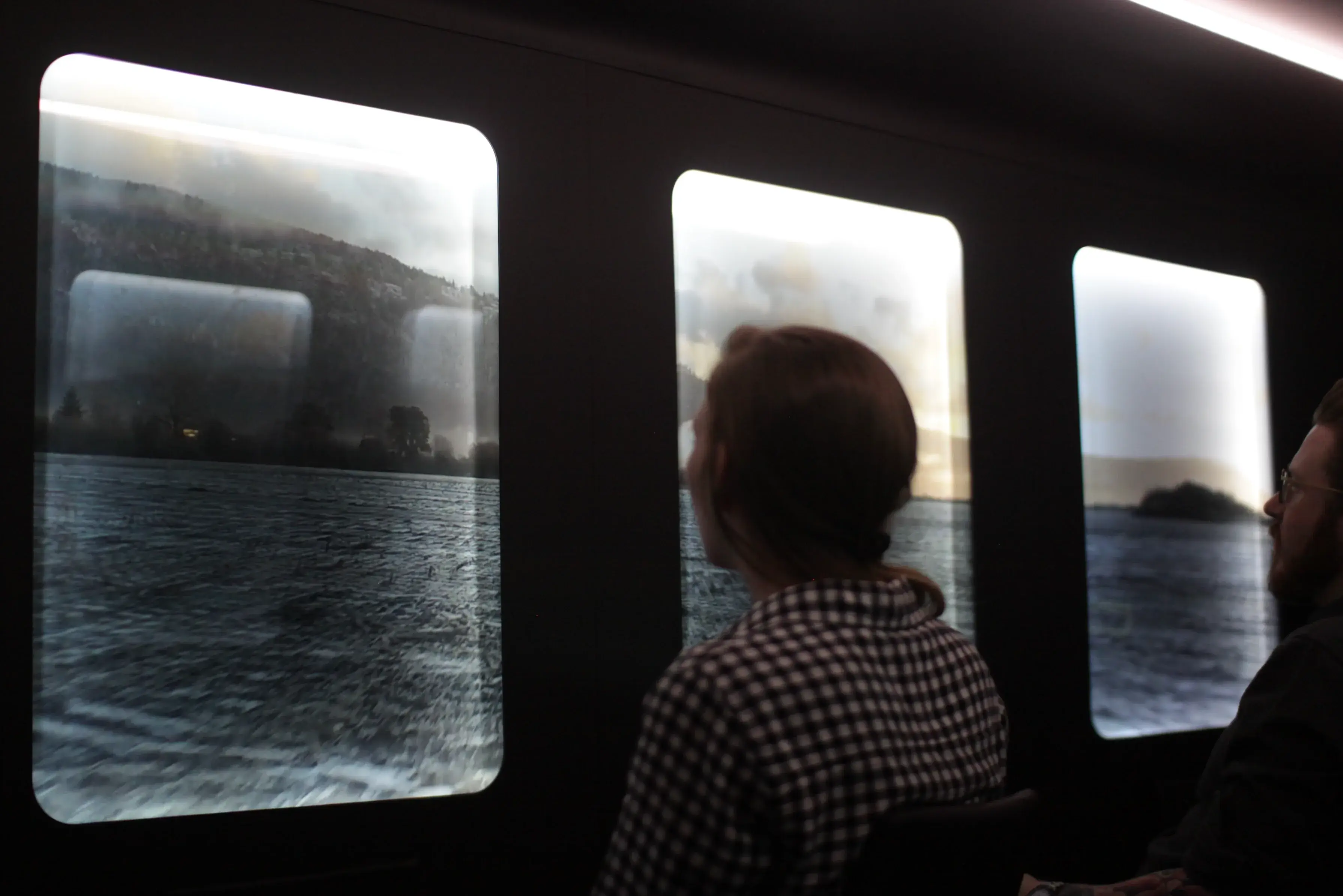 Visitors looking through bus windows showing an ocean landscape overlaid on the glass, demonstrating immersive AR content